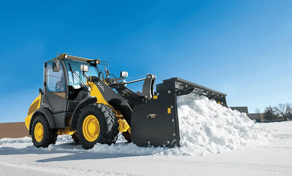 Compact Loader pushing snow